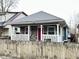 Charming home featuring a stone facade, inviting front porch with white railings and a vibrant red front door at 309 N Forest Ave, Indianapolis, IN 46201