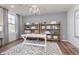Stylish home office featuring wood shelves, a white desk, a patterned rug, and natural light from a window at 3256 Fawn Cir, Brownsburg, IN 46112