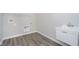 Bright laundry room with wood-style flooring, utility sink, and modern washer/dryer hookups at 3256 Fawn Cir, Brownsburg, IN 46112