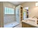 Modern bathroom showcases a walk-in shower with glass block window and wood shelving next to a vanity sink at 3273 Bailey Dr, Morgantown, IN 46160