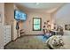 Comfortable bedroom boasts a mounted TV, natural light, and a charming vanity and chair at 3273 Bailey Dr, Morgantown, IN 46160