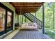 Inviting outdoor patio with swing bed, offering a serene woodland view and access to staircase at 3273 Bailey Dr, Morgantown, IN 46160