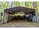 Open shed filled with firewood and equipment, nestled in a leafy wooded area at 3273 Bailey Dr, Morgantown, IN 46160