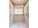 Tiled shower with glass block window and rainfall showerhead, creating a spa-like experience at 3273 Bailey Dr, Morgantown, IN 46160