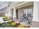 Cozy covered front porch featuring a seating area, decorative planters, and a serene outdoor ambiance at 3622 S Setting Sun Ln, New Palestine, IN 46163