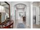 Elegant hallway featuring hardwood floors, arched doorways, and decorative mirrors creating a seamless flow at 3622 S Setting Sun Ln, New Palestine, IN 46163
