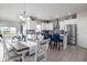 An open-concept kitchen with white cabinets, stainless steel appliances, and a breakfast bar with blue chairs at 3622 S Setting Sun Ln, New Palestine, IN 46163