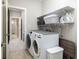 A practical laundry room featuring a modern washer and dryer with ample shelf storage at 3622 S Setting Sun Ln, New Palestine, IN 46163