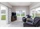 A bright sunroom featuring large windows, comfortable seating, and access to the outdoors at 3622 S Setting Sun Ln, New Palestine, IN 46163