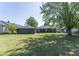 Large green backyard with mature tree coverage featuring the exterior of the house at 370 N Bazil Ave, Indianapolis, IN 46219