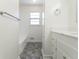 Bright bathroom features a tub with tiled wall and a gray tiled floor at 370 N Bazil Ave, Indianapolis, IN 46219