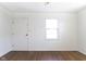 Bedroom features hardwood floors, a bright window, and fresh white walls at 370 N Bazil Ave, Indianapolis, IN 46219