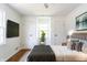 Staged bedroom has hardwood floors, double closets, and tranquil aesthetic at 370 N Bazil Ave, Indianapolis, IN 46219