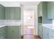 A look into the kitchen that features green cabinetry and white subway tile backsplash at 370 N Bazil Ave, Indianapolis, IN 46219