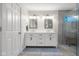 Bright bathroom featuring a double vanity with framed mirrors and a glass enclosed shower at 3781 S Station Dr, Columbus, IN 47203