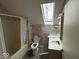 Bathroom featuring shower/tub, toilet, sink, mirror, and a skylight for natural light at 3917 Knoll Wood Ln, Anderson, IN 46011