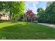 Exterior of a light brick home with mature trees and a well-manicured lawn at 3917 Knoll Wood Ln, Anderson, IN 46011