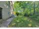 Spacious and well-maintained side yard with mature trees and lush greenery at 3917 Knoll Wood Ln, Anderson, IN 46011