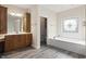 Bright bathroom with a soaking tub, decorative window, and wood-look flooring at 4139 Bayberry Ct, Greenwood, IN 46143