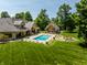 Aerial view showcasing a pool, a pool house, and a manicured backyard surrounded by lush trees at 4242 Watson Rd, Greenwood, IN 46143