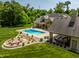 Aerial view of a property featuring a pool, fire pit, outdoor kitchen, and lush landscaping at 4242 Watson Rd, Greenwood, IN 46143