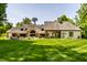 Expansive backyard featuring a covered patio, lush greenery, and a grand home exterior at 4242 Watson Rd, Greenwood, IN 46143
