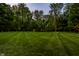 Immaculate backyard featuring a plush, well-manicured lawn with unique striping and a fire pit at 4242 Watson Rd, Greenwood, IN 46143