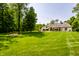 Wide backyard view showcases the expansive lawn and a fire pit area with a home in the background at 4242 Watson Rd, Greenwood, IN 46143
