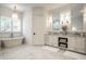 Bright bathroom features a freestanding tub, marble floors, and dual sink vanity with modern fixtures at 4242 Watson Rd, Greenwood, IN 46143