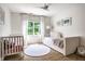 Bright Bedroom with white crib, daybed, round rug, and large window, perfect for a cozy and cheerful space at 4242 Watson Rd, Greenwood, IN 46143