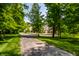 Long driveway leading up to a large home surrounded by mature trees and lush green lawn at 4242 Watson Rd, Greenwood, IN 46143