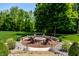 Scenic backyard fire pit area with Adirondack chairs, stone surround, and lush green surroundings at 4242 Watson Rd, Greenwood, IN 46143