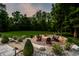 Custom fire pit surrounded by Adirondack chairs in a beautifully landscaped backyard at 4242 Watson Rd, Greenwood, IN 46143