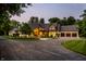 An attractive home exterior featuring a circular driveway, professional landscaping, and warm lighting at 4242 Watson Rd, Greenwood, IN 46143