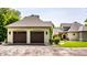 Spacious two-car garage with classic brown doors, situated on manicured grounds with complementary house architecture at 4242 Watson Rd, Greenwood, IN 46143