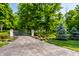 Gated entrance to a sprawling estate with mature trees and manicured landscaping at 4242 Watson Rd, Greenwood, IN 46143