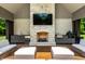 Inviting outdoor living space with stone fireplace, TV, grill, and comfortable seating, perfect for relaxation and entertainment at 4242 Watson Rd, Greenwood, IN 46143