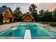 Beautiful pool area with an outdoor kitchen, fireplace, and ample seating for entertainment at 4242 Watson Rd, Greenwood, IN 46143