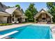 A sparkling swimming pool with a diving board, complemented by a spacious backyard and pool house at 4242 Watson Rd, Greenwood, IN 46143