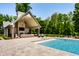 Beautiful pool house with an outdoor kitchen, seating area, and fireplace, perfect for entertaining at 4242 Watson Rd, Greenwood, IN 46143