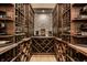 Custom wine cellar with stone accent wall and built-in wooden racks for ample bottle storage at 4242 Watson Rd, Greenwood, IN 46143
