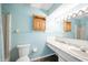 Bathroom featuring a toilet, sink, and shower, complemented by a light blue color scheme at 4316 London Ct, Anderson, IN 46013
