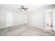 A simplistic bedroom features neutral walls, carpet, and a ceiling fan above with an attached bathroom at 4316 London Ct, Anderson, IN 46013