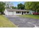 Exterior view of home features a long driveway, brick exterior, black trim, and garage access at 4482 Priscilla Ave, Indianapolis, IN 46226