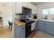Bright kitchen boasts stainless steel appliances, butcher block counters, and tiled backsplash at 4482 Priscilla Ave, Indianapolis, IN 46226