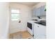 Practical laundry room features washer, dryer, updated cabinets, and door to outside at 4482 Priscilla Ave, Indianapolis, IN 46226