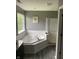 Bright bathroom showcasing a corner soaking tub, large window, and glass shower door at 450 Columbia Ct, Greenwood, IN 46142