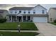 Charming two-story home featuring a well-manicured lawn, white picket fence, and a spacious two-car garage at 450 Columbia Ct, Greenwood, IN 46142