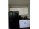 Modern kitchen with white cabinetry, dark countertops, and a black refrigerator at 450 Columbia Ct, Greenwood, IN 46142