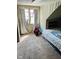 Quaint attic bedroom with carpet flooring, natural light from a large window, and built-in shelves for extra storage at 4850 E University Ave, Indianapolis, IN 46201